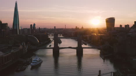 Aerial-View-of-London,-including-Towerbridge,-the-Shard,-and-the-river-Thames-as-the-sunsets