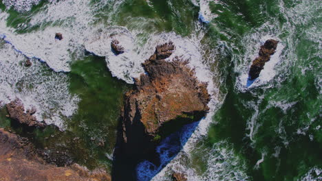 Aerial-descending-above-ocean-rock,-breaking-waves-patterns,-textures