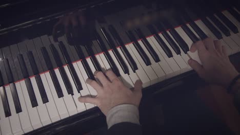 Männlicher-Pianist-Spielt-Ein-Lied-Auf-Dem-Klavier-Bei-Schwachem-Licht-Und-Blick-über-Die-Schulter