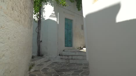 POV-moving-through-narrow-Greek-alley-with-typical-blue-doors-and-windows
