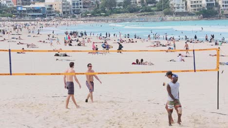 Un-Grupo-De-Cuatro-Amigos-Jugando-Un-Partido-De-Voleibol-De-Playa-En-Un-Día-De-Primavera-En-Bondi-Beach,-Sydney,-Australia.