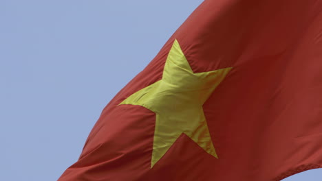 Video-4k-De-La-Bandera-Nacional-De-Vietnam-Bajo-Un-Sol-Brillante-Con-Cielo-Azul-Y-Fondo-De-Nubes