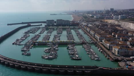 Establishing-aerial-dolly-reveal-from-Brighton-marina-to-show-the-town,-Pier,-beach---I360
