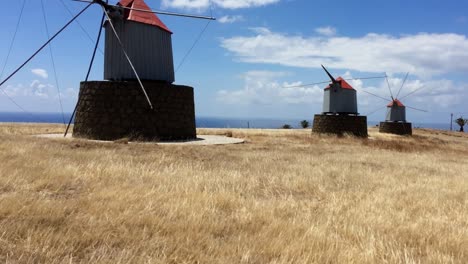 Tilt-shot-of-out-of-production-windmill-in-the-desert-island-of-Porto-Santo,-dry-isle-that-has-the-tendency-to-catch-wind-hence-a-high-number-of-windmills-were-built-there