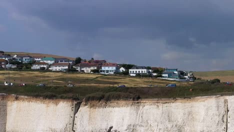 Aerial-tracking-shot-of-holiday-makers-using-the-A259-coast-road-near-Brighton,-UK-with-its-infamous-white-cliffs