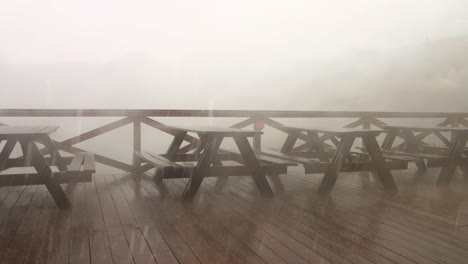 Empty-benches-in-a-garden-restaurant-during-extreme-cloud-burst