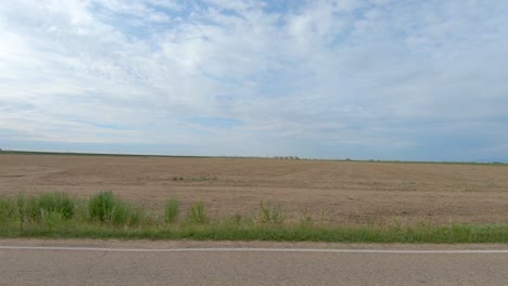 A-big-sky-and-plowed-fields-are-evident-in-this-roadside-drive