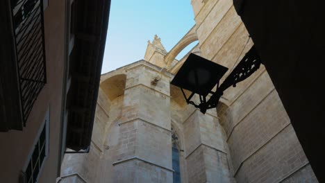 Low-Angle-Reveal-of-The-Cathedral-of-Santa-Maria-of-Palma-From-Between-Buildings