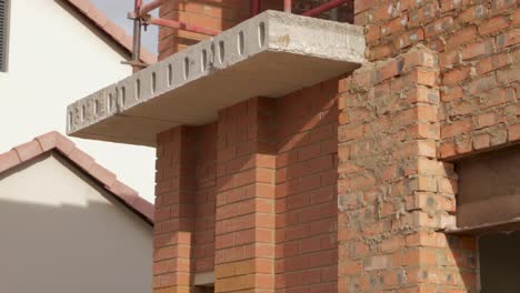 Tilt-shot-of-new-house-construction-site-showing-scaffolding-and-brick-wall