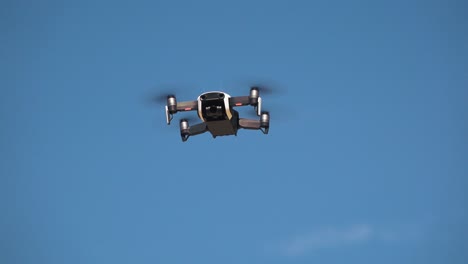Close-Shot-of-a-Drone-Flying-With-a-Blue-Sky-Background