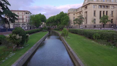 Looking-along-a-canal-in-Perpignan-city-center-on-a-hot-but-windy-day-in-early-summer