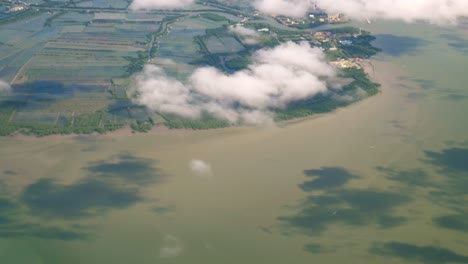 Una-Vista-De-La-Ventana-Del-Avión-Superior-Mientras-Flota-En-El-Aire,-Con-Vistas-A-Las-Montañas-Y-Los-Recursos-Hídricos-Naturales-A-Lo-Largo-De-La-Costa-De-Tailandia