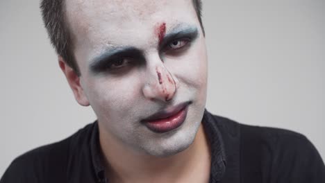 Man-with-face-paint-and-creepy-angry-smile,-closeup-portrait