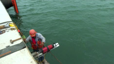 tilt-down-from-the-ocean-to-a-man-drilling-floating-on-a-platform