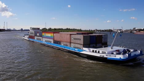 Mercur-Freight-Cargo-Container-Ship-Crossing-The-Canal-River-Near-Kinderdijk-In-Molenlanden,-Netherlands