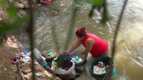 Eine-Frau-Wäscht-Ihre-Wäsche-Am-Ufer-Des-Flusses