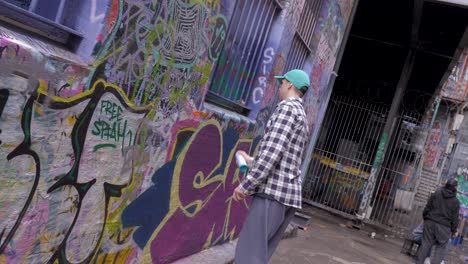 Junger-Graffiti-Künstler-Malt-Mit-Roter-Sprühfarbe-In-Hoiser-Lane,-Melbourne,-Juli-2019-Graffiti-An-Der-Wand,-Straßenspray-Kunstwerk-In-Hosier-Lane,-Melbourne,-CBD