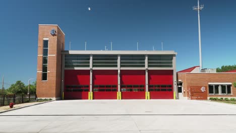 Exterior-of-Fire-Station-on-Clear-Summer-Day-with-Red-Garage-Doors-and-Bricks
