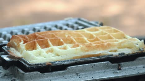 Close-Shot-of-a-Waffle-Iron-Being-Opened-with-the-Waffle-Being-Removed-with-Tongs