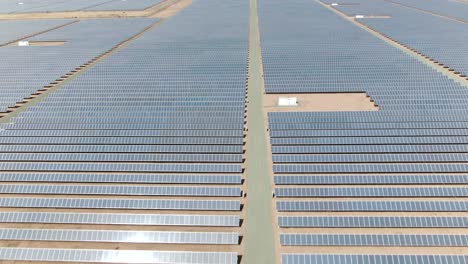 Forward-moving-aerial-shot-over-multiple-rows-of-solar-panels-in-California,-USA