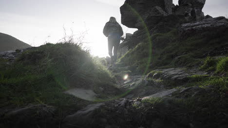 Frau-Klettert-Und-Wandert-Im-Tal-Der-Felsen-Im-Gegenlicht-Des-Sonnenlichts-In-Lynton,-England,-Vereinigtes-Königreich