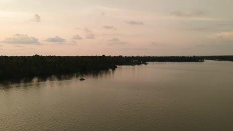 Beautiful-aerial-shot-of-a-backwater-Vembanadu-Lake,water-lines,twilight-sunset,coconut-trees-,water-transportation,clouds,reflation,House-boat,red-sky