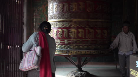 Katmandú,-Nepal---16-De-Noviembre-De-2019:-Gente-Caminando-Alrededor-De-Una-Gran-Rueda-De-Oración-Y-Haciéndola-Girar-En-El-Bhouddha-En-Katmandú
