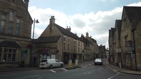 Quiet-street-with-low-traffic-in-a-small-English-village-Tetbury-during-summer-with-blue-sky-and-white-clouds