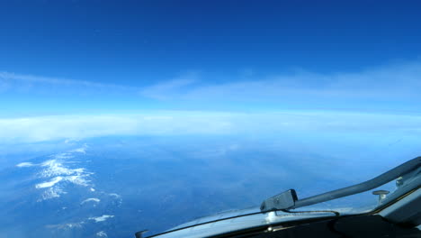 Cockpit-view-of-clouds-passing-above-snow-capped-Alps-mountain-ranges