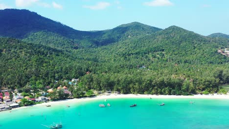Calm-clear-water-of-turquoise-lagoon-washing-pristine-exotic-beach-with-white-sand-on-tropical-island-with-green-hills-in-Thailand