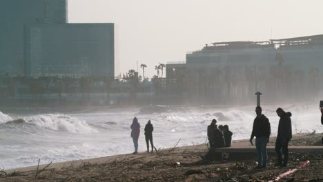 60FPS:-Huge-waves-crash-on-the-beach-in-Barcelona-after-a-devastating-storm,-people-take-pictures---zoomed-shot