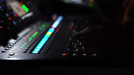 Mixing-consolle-with-blinking-volume-level,-lateral-view-with-blurred-background