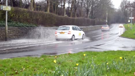 Cars-driving-and-splashing-through-heavy-flooded-stormy-severe-flash-flood-road