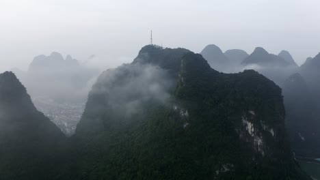 Montañas-Yangshuo-4k-Drone-Empujan-Desde-La-Torre-De-Televisión-Sobre-Las-Nubes-Brumosas