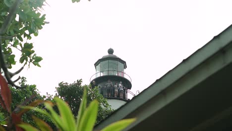 Key-West-Lighthouse-From-Ground-Level-With-Foliage-in-Foreground