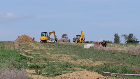 Yellow-tractor-and-excavator-working-on-a-new-house-which-are-built-in-by-a-developer-company