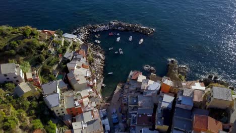 Stadt-Riomaggiore-In-Den-Cinque-Terre,-Italien,-Mit-Gebäuden-Und-Booten-In-Der-Nähe-Des-Meeres,-Luftbildaufnahme