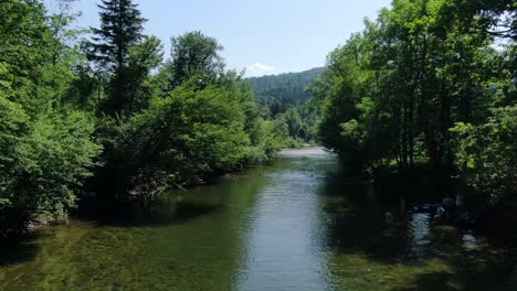 Nahe-über-Einem-Fluss-In-Osilnica-In-Slowenien-In-Der-Natur-Fliegen,-Während-Die-Menschen-Im-Fluss-Schwimmen-Und-Spaß-Haben