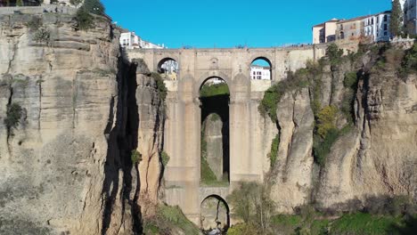 Village-of-Ronda-Spain-Puente-Nuevo-arch-bridge-in-the-province-of-Málaga-Andalucia,-Aerial-pedestal-lift-shot