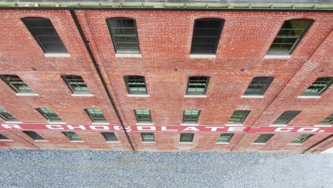 Descending-aerial-along-red-brick-wall-of-Wilbur-Chocolate-Company-renovated-into-condos