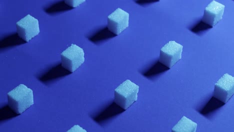 A-4K-tilt-up-view-of-a-unique-cubic-background-with-white-sugar-cubes-arranged-in-rows-on-a-dark-blue-background,-3D-effect