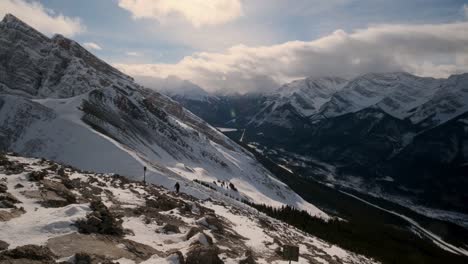 Tourists-Enjoy-the-Amazing-View-from-a-Snowy-Mountain-Peak,-Wide-Pan