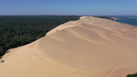 Group-of-People-at-the-summit-of-Dune-du-Pilat-in-Arcachon-Bassin-France,-Aerial-close-in-shot