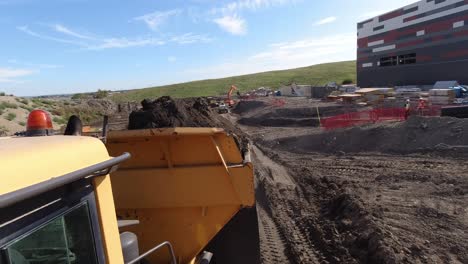 Action-cam-shot-of-a-dumper-truck-reversing-ready-to-tip-earth-on-a-large-construction-site