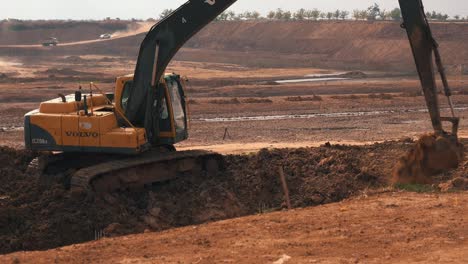 Medium-Shot-of-a-Digger-Excavating-Soil-on-a-Large-Construction-Site-in-Asia
