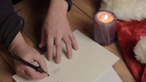 Hand-writing-out-Christmas-greeting-cards-with-candle