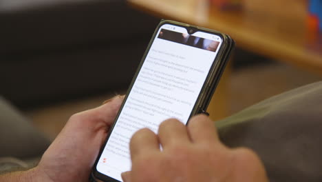 A-close-up-of-a-smartphone-as-a-man-scrolls-through-the-news-about-the-coronavirus-in-Australia