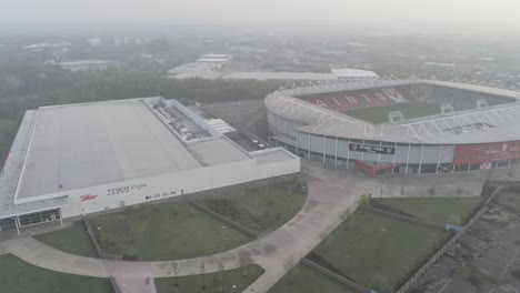 North-West-Tesco-retail-and-Saints-rugby-stadium-misty-aerial-morning-during-covid-corona-lock-down-dolly-right
