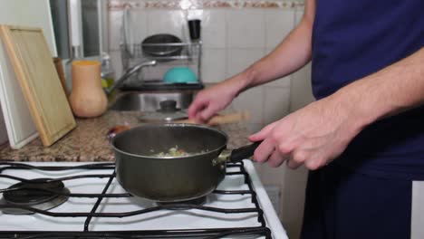 Young-adult-cooking-homemade-vegetarian-food-in-saucepan