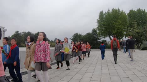 Kamerafahrt-Von-Touristen,-Die-In-Der-Nähe-Einer-Gruppe-Nordkoreanischer-Schulkinder-Und-Ihrer-Lehrer-Spazieren